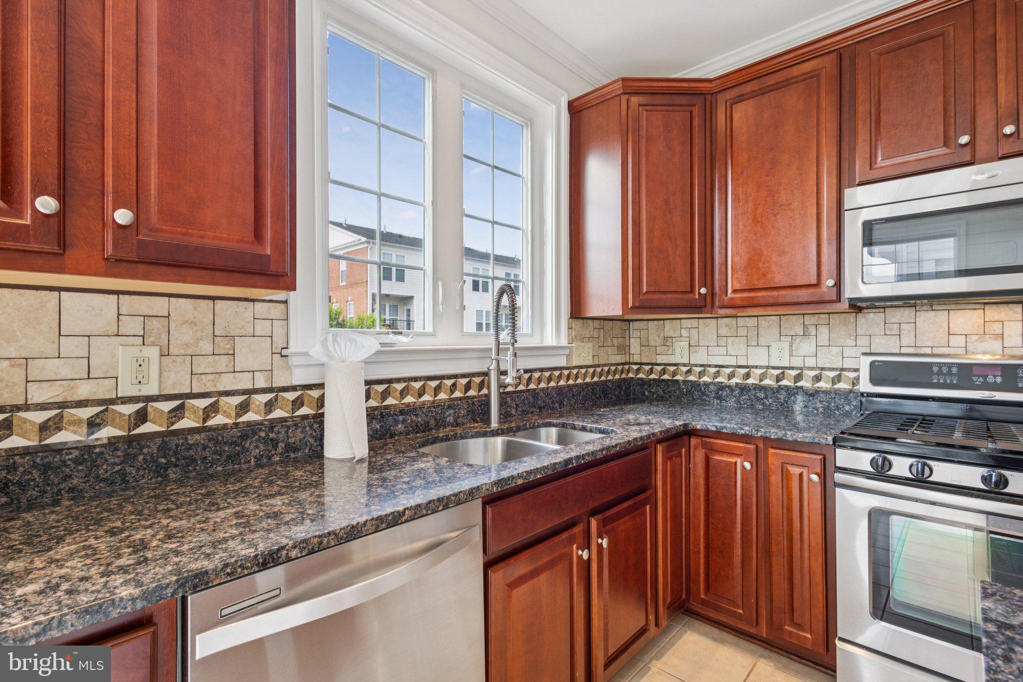 42761 Hay Road Ashburn, VA 20147 - Photo 7 of 46 a kitchen with stainless steel appliances granite countertop a sink stove and cabinets