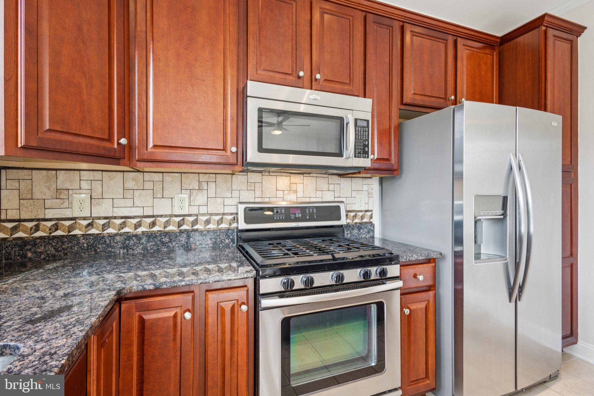 42761 Hay Road Ashburn, VA 20147 - Photo 8 of 46 a kitchen with stainless steel appliances granite countertop a stove microwave and refrigerator