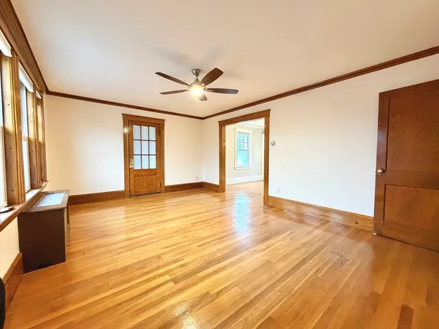 a view of an empty room with glass door and wooden floor