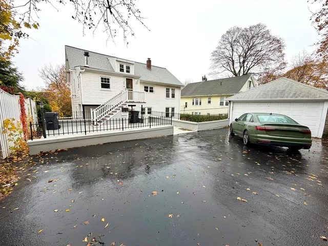 a view of a street with a cars parked in front of a house