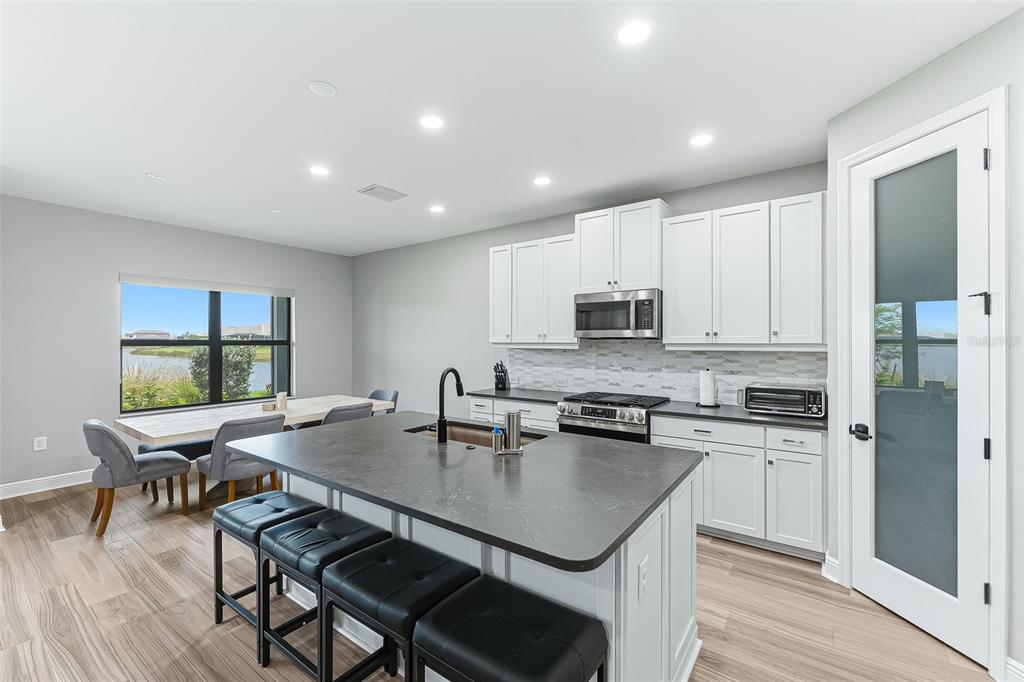 4191 Pegasus Way Naples, FL 34120 - Photo 10 of 48 a kitchen with stainless steel appliances a table chairs refrigerator and cabinets