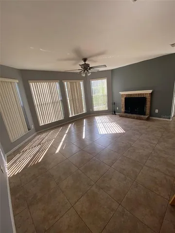 a view of an empty room with a fireplace and a window