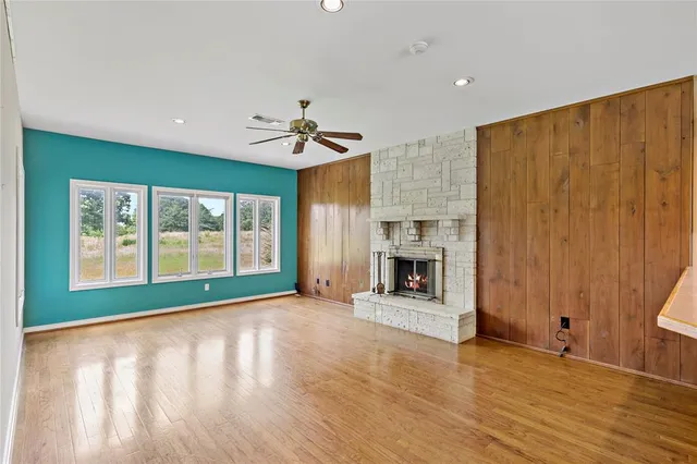 a view of an empty room with a window and fireplace