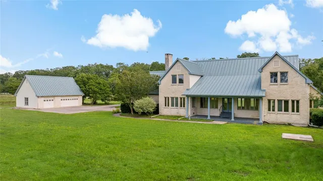 a front view of a house with a yard and trees