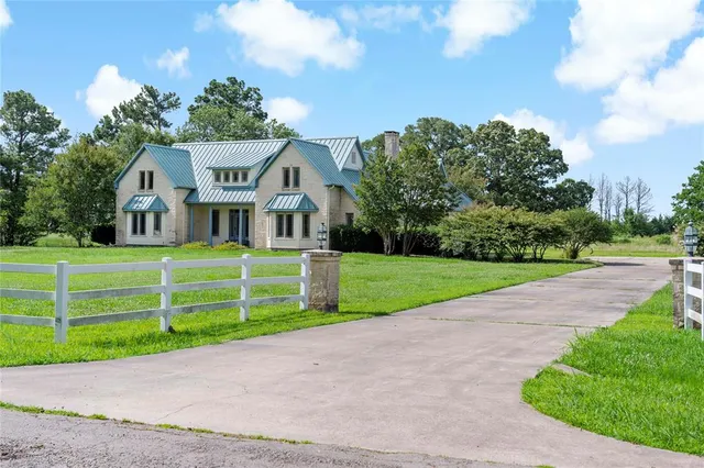 a front view of a house with a yard and potted plants