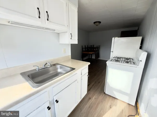 a kitchen with a sink a stove and cabinets