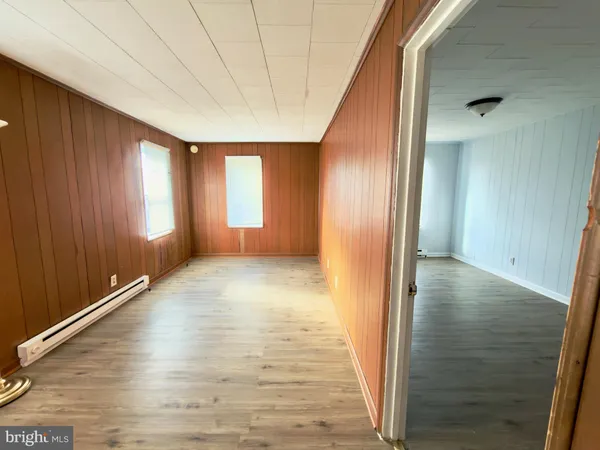 a view of hallway with a window and wooden floor