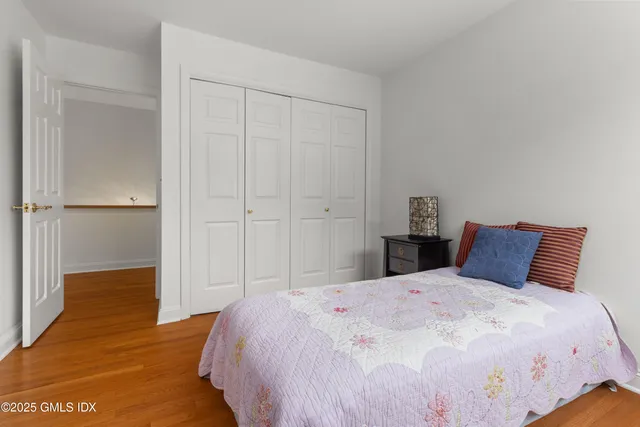 a bedroom with a large bed and wooden floor