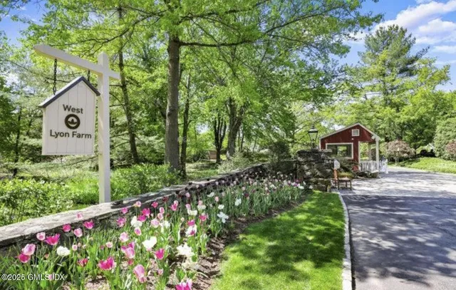 a front view of a house with a yard and fountain in middle