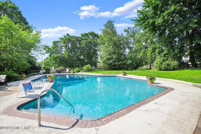 a view of a swimming pool with a yard and sitting space