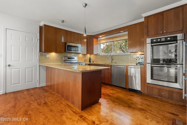 a kitchen with stainless steel appliances granite countertop a stove a sink and a refrigerator