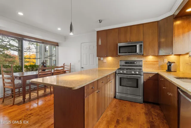 a kitchen with stainless steel appliances granite countertop a sink stove and microwave