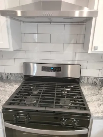 a stove top oven sitting inside of a kitchen