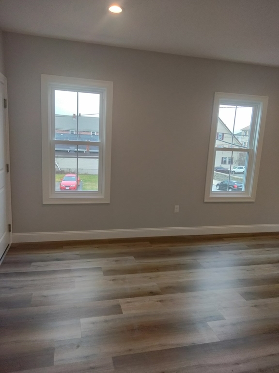 269 Brightman Street, Unit 2 Fall River, MA 02720 - Photo 4 of 12 an empty room with wooden floor and windows