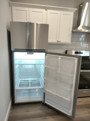 a view of kitchen with a sink and a refrigerator
