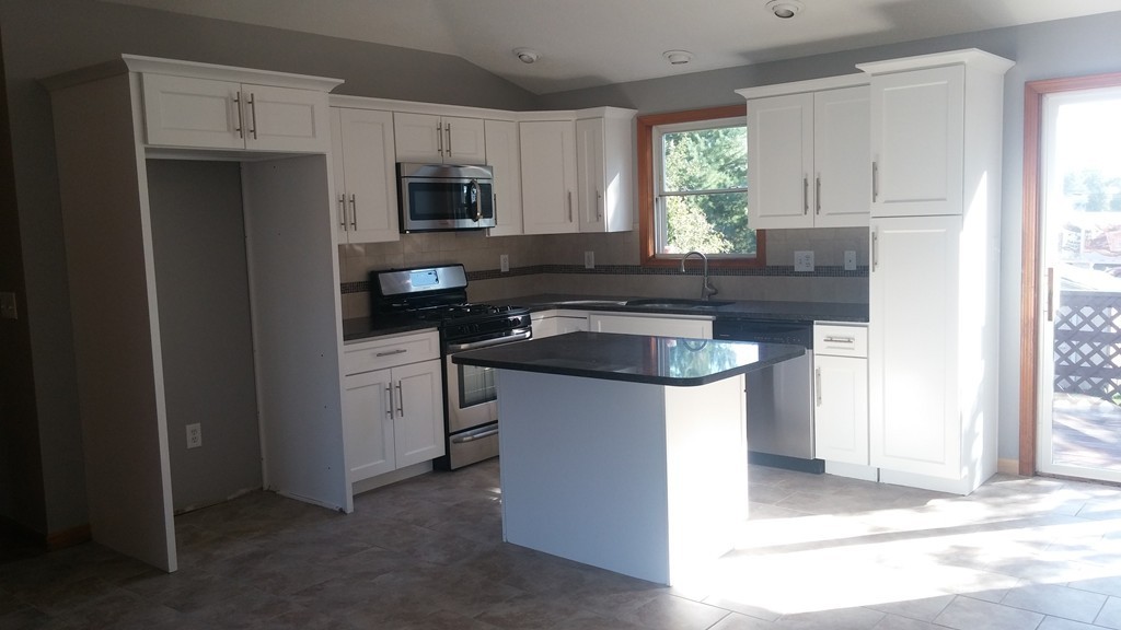 1323 Slade Street Fall River, MA 02721 - Photo 5 of 12 a kitchen with stainless steel appliances granite countertop a sink stove and refrigerator
