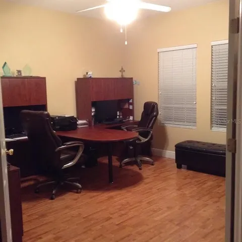 a view of a workspace with furniture and a window