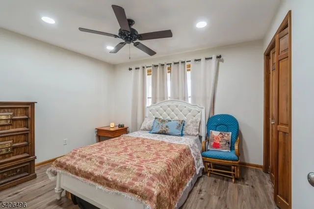 a bedroom with a bed a chandelier and a dresser
