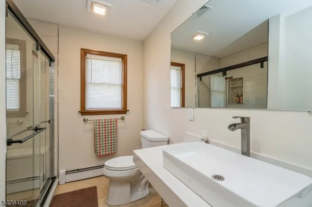 a bathroom with a sink a toilet and shower