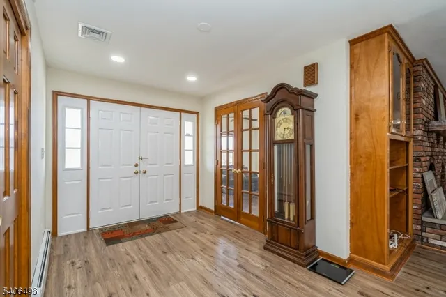 a view of a room with wooden floor window and front door