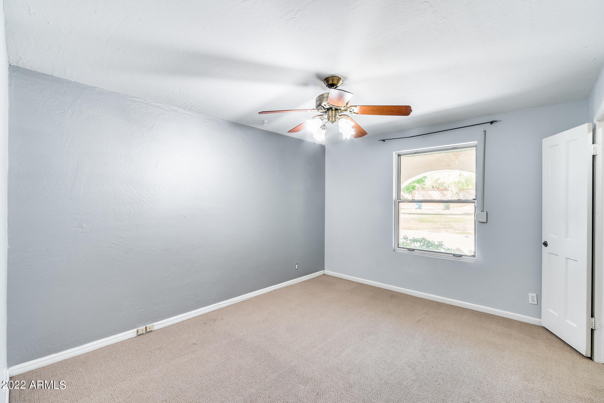 5501 East Camelback Road Phoenix, AZ 85018 - Photo 24 of 53 an empty room with windows and chandelier fan