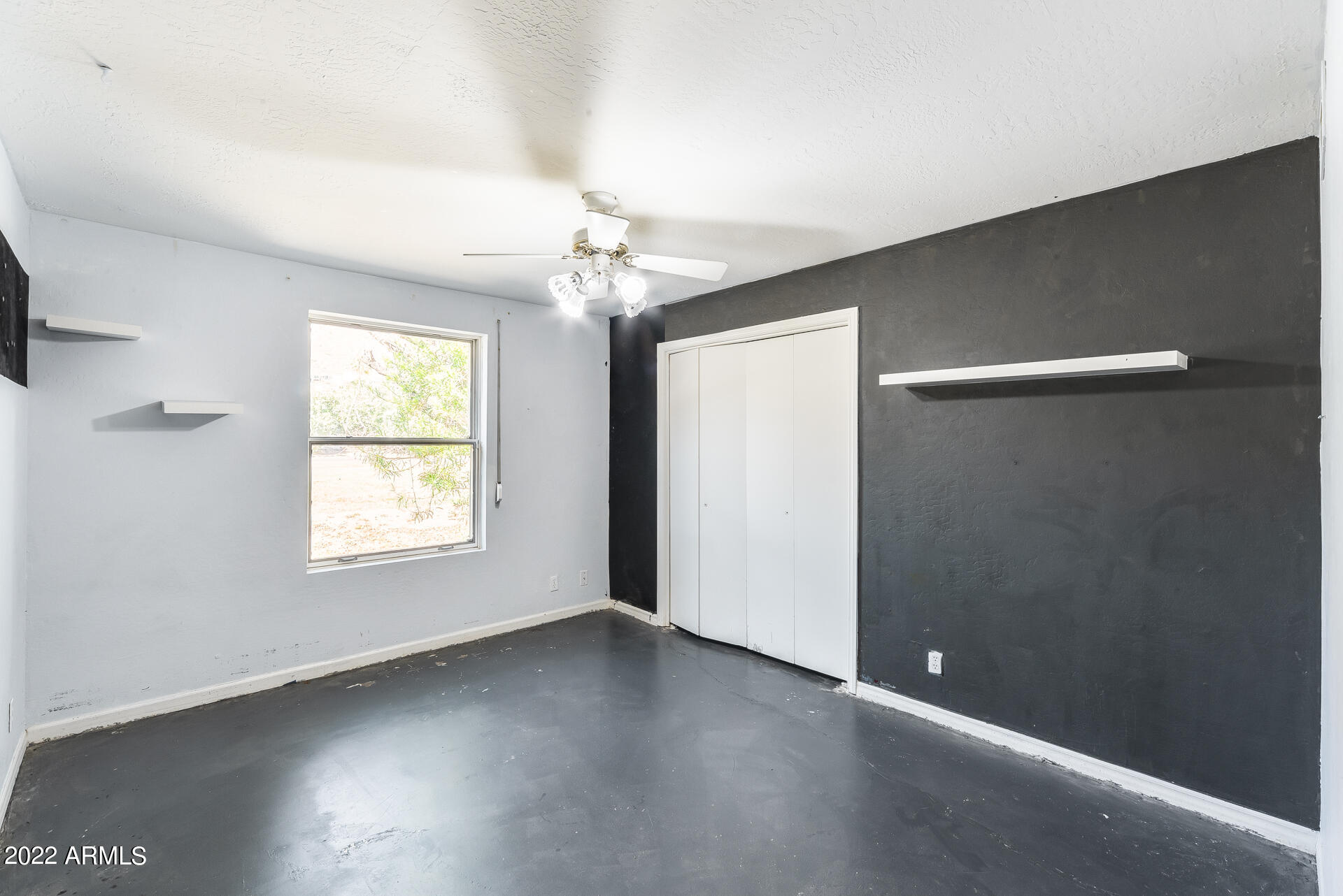 5501 East Camelback Road Phoenix, AZ 85018 - Photo 31 of 53 an empty room with wooden floor chandelier and windows