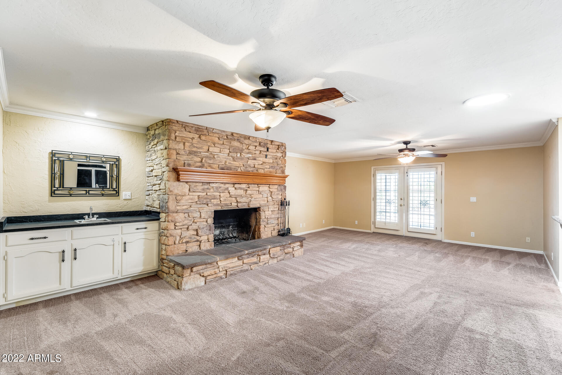 5501 East Camelback Road Phoenix, AZ 85018 - Photo 9 of 53 a view of a livingroom with a fireplace a ceiling fan and windows