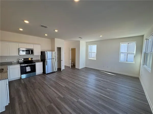 a view of kitchen with stove and refrigerator