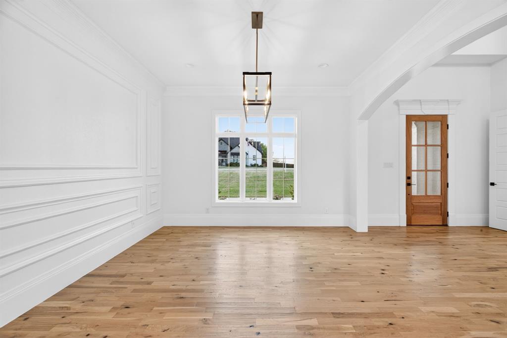 7798 Barber Rnch Road Fort Worth, TX 76126 - Photo 7 of 40 a view of an empty room with wooden floor and a window