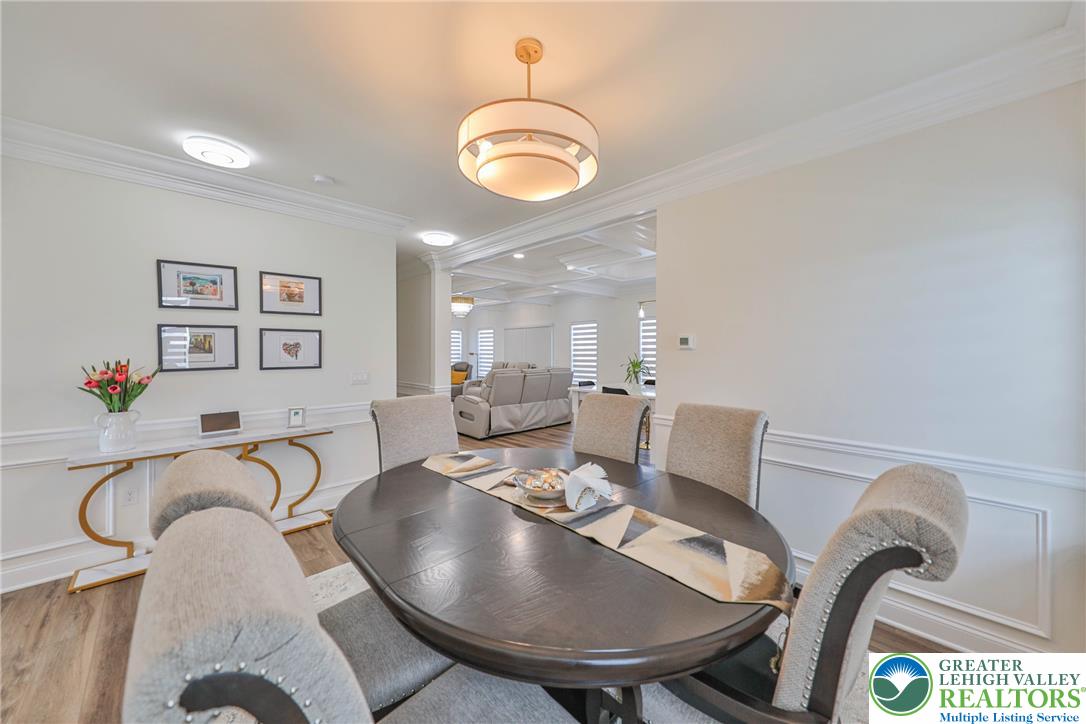 1105 Meco Road Easton, PA 18040 - Photo 22 of 100 Elegant crown molding and wainscoting line this open-concept dining space with hardwood flooring.