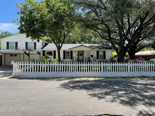 a view of a white house with a small yard