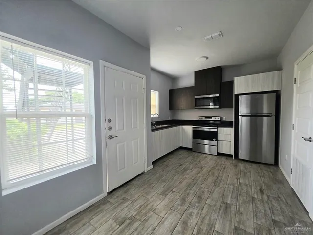 a kitchen with stainless steel appliances granite countertop a refrigerator and a stove top oven