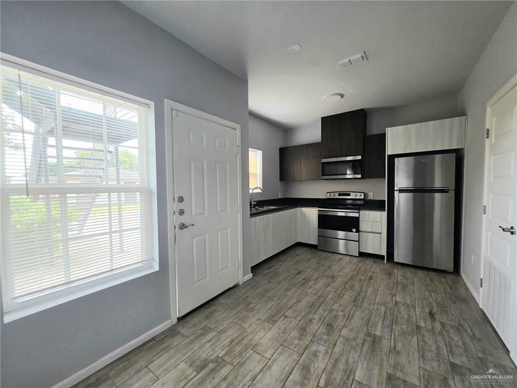 1514 Quitaca Drive, Unit 3 Edinburg, TX 78541 - Photo 2 of 10 a kitchen with stainless steel appliances granite countertop a refrigerator and a stove top oven