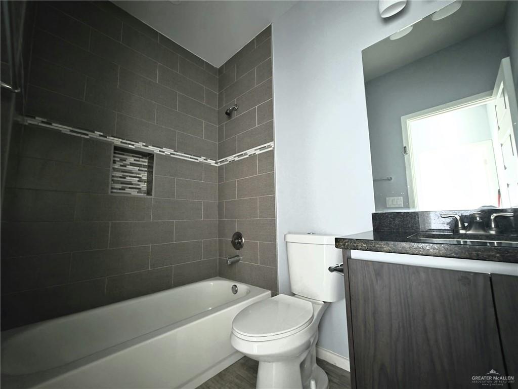 1514 Quitaca Drive, Unit 3 Edinburg, TX 78541 - Photo 7 of 10 a bathroom with a granite countertop sink toilet and shower