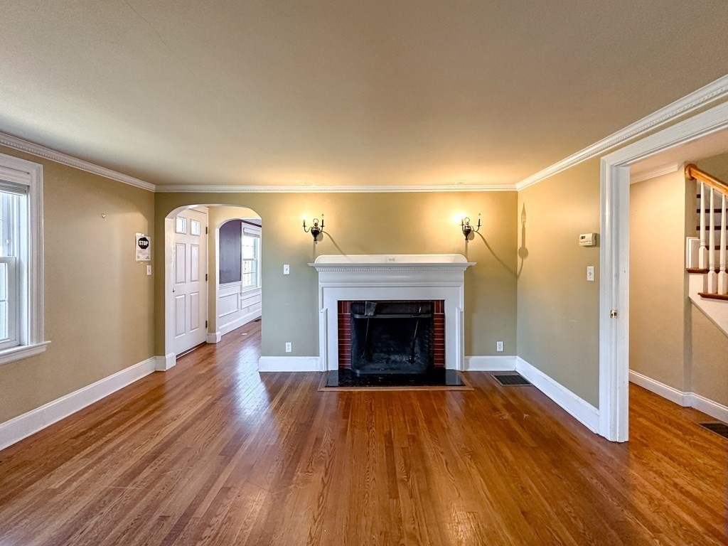 29 Douglas Road Needham, MA 02492 - Photo 11 of 42 an empty room with wooden floor and fireplace