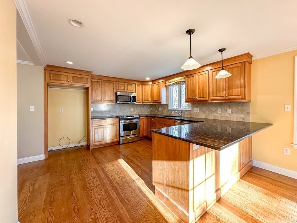 29 Douglas Road Needham, MA 02492 - Photo 4 of 42 a kitchen with stainless steel appliances granite countertop a sink a stove and a wooden floor