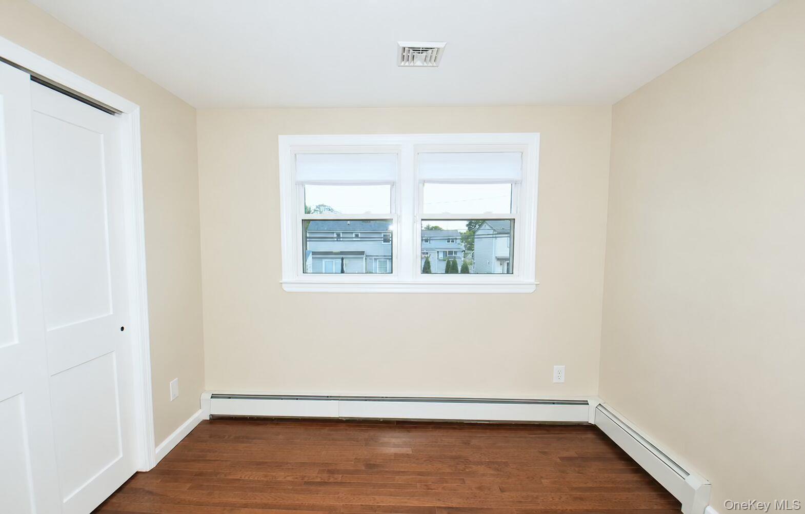 4195 Florence Road Bethpage, NY 11714 - Photo 17 of 23 an empty room with wooden floor and windows