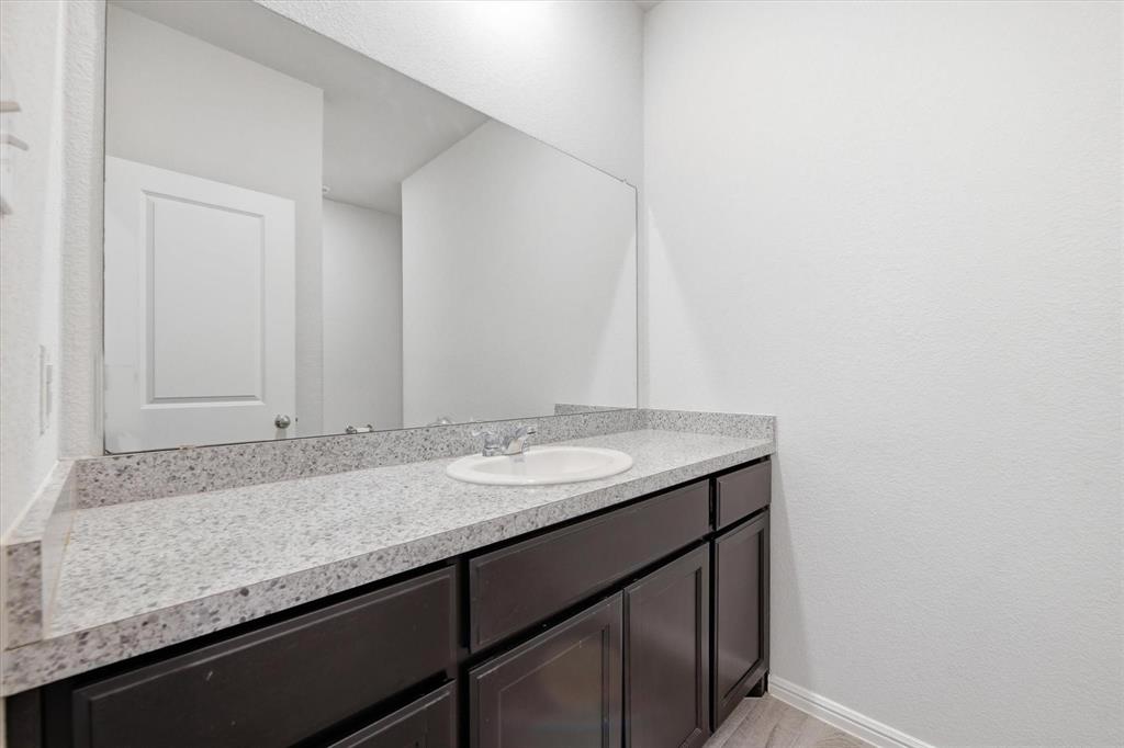 9308 Desertrock Road Fort Worth, TX 76131 - Photo 23 of 29 a bathroom with a granite countertop sink and a mirror