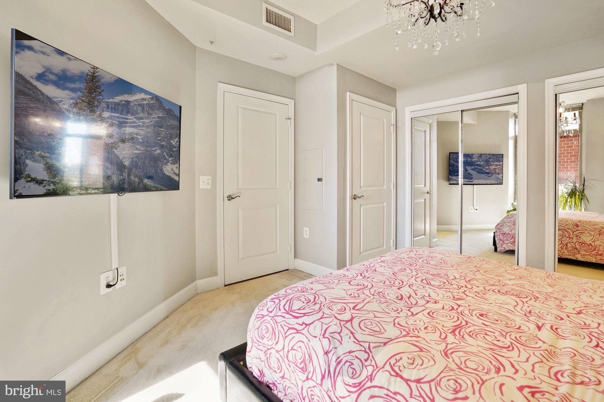 3600 South Glebe Road, Unit 632W Arlington, VA 22202 - Photo 16 of 41 a bedroom with a large bed and a chandelier