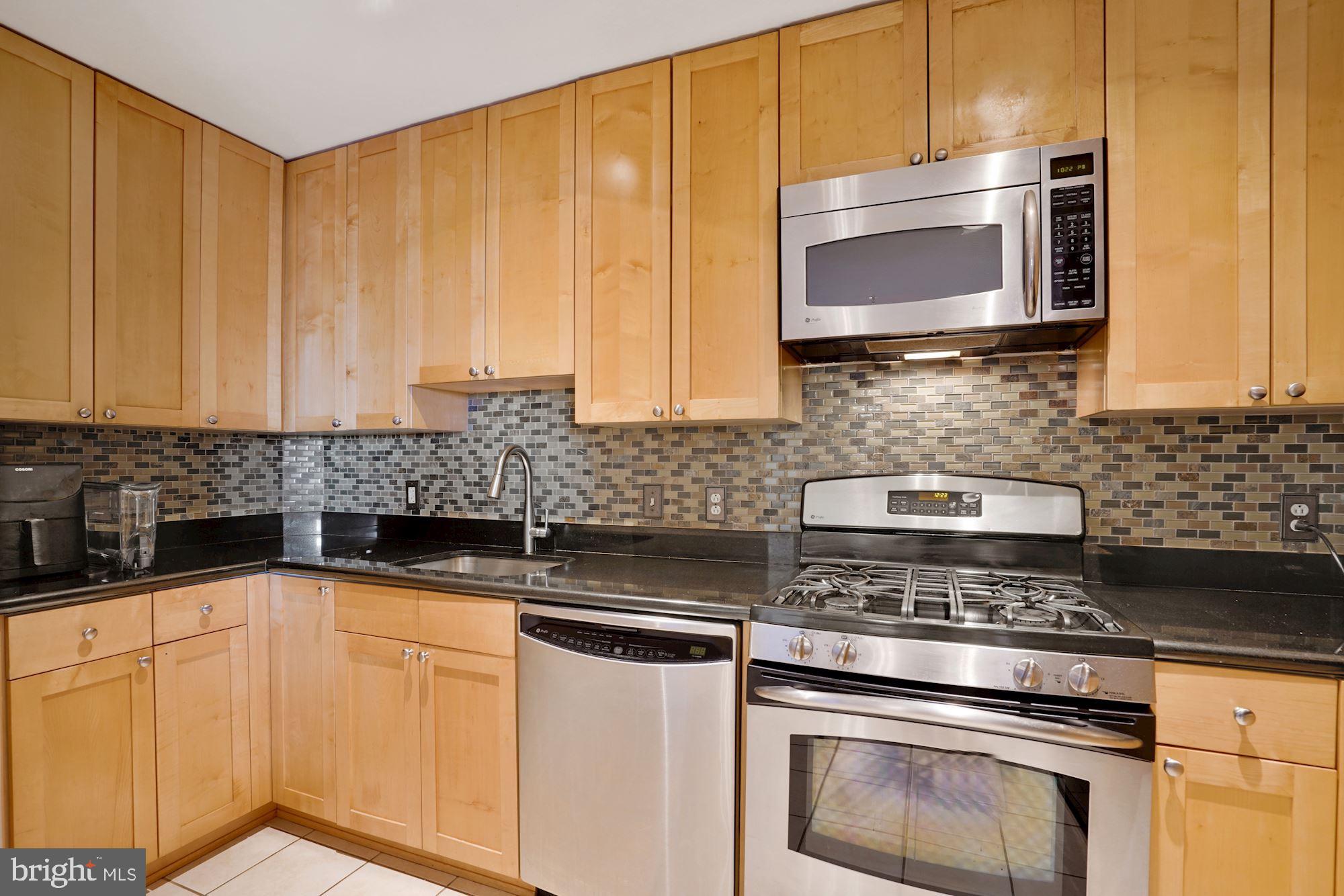 3600 South Glebe Road, Unit 632W Arlington, VA 22202 - Photo 6 of 41 a kitchen with granite countertop white cabinets stainless steel appliances and a sink