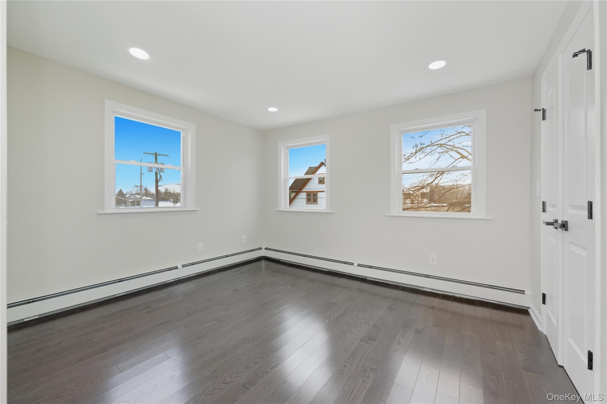 120 Maple Avenue, Unit 2 Cedarhurst, NY 11516 - Photo 7 of 17 a view of an empty room with a window and wooden floor