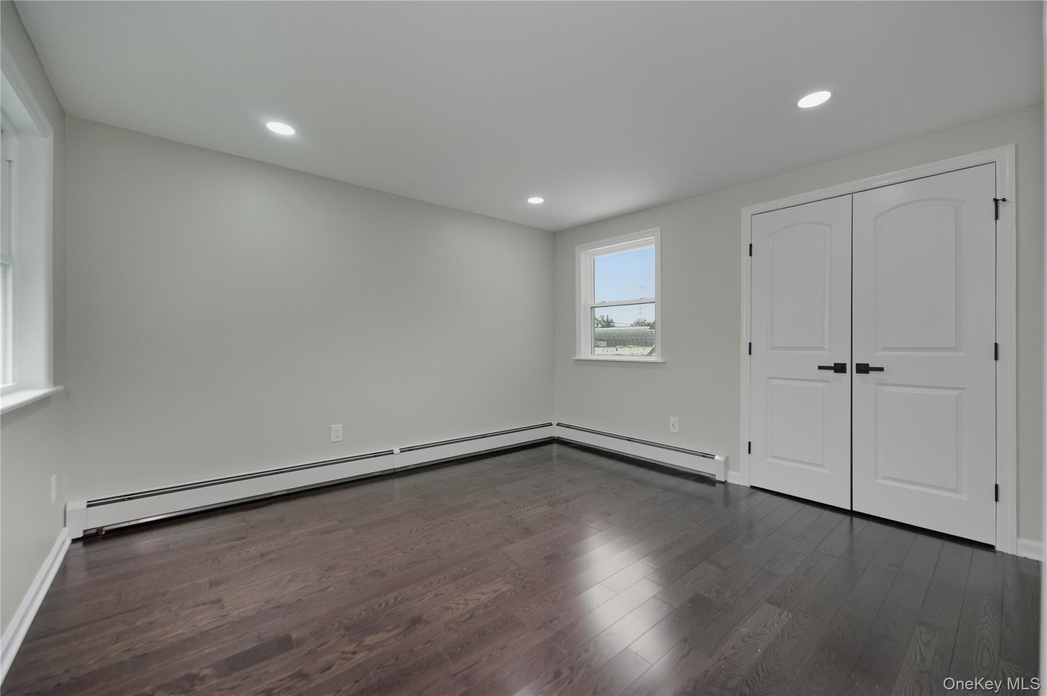 120 Maple Avenue, Unit 2 Cedarhurst, NY 11516 - Photo 8 of 17 an empty room with wooden floor and windows