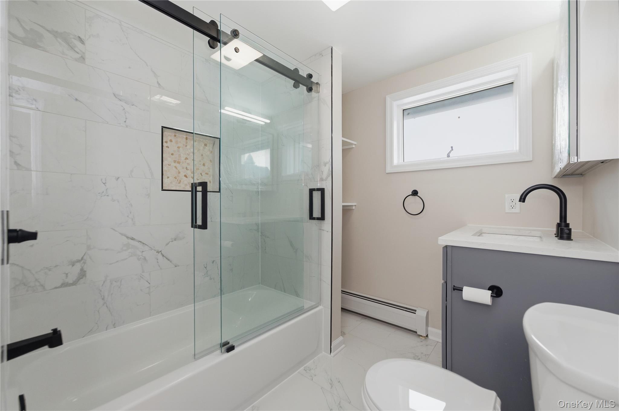 120 Maple Avenue, Unit 2 Cedarhurst, NY 11516 - Photo 9 of 17 a bathroom with a sink toilet a mirror and shower