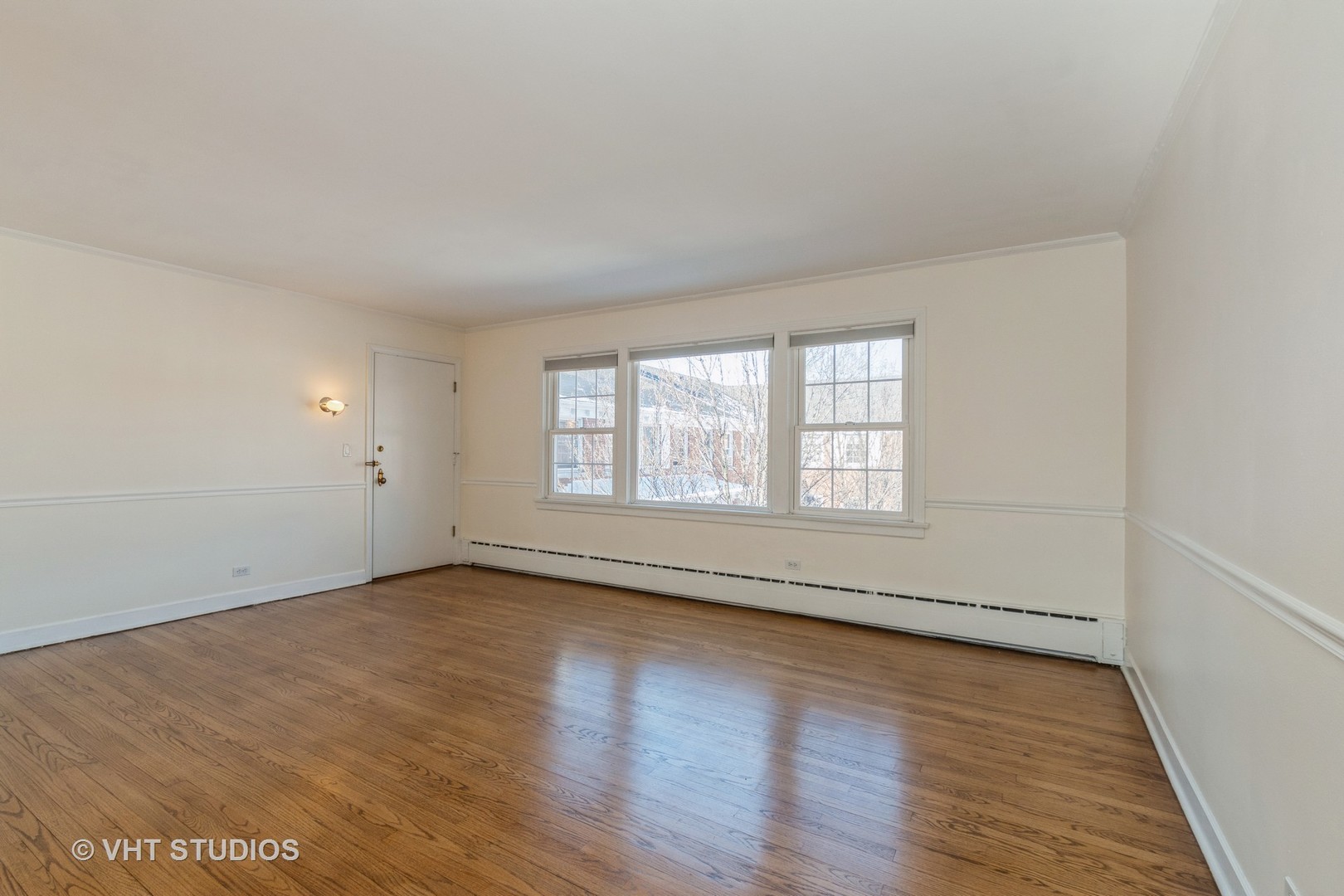 334 Ridge Avenue, Unit 3 Evanston, IL 60202 - Photo 3 of 12 an empty room with wooden floor and windows