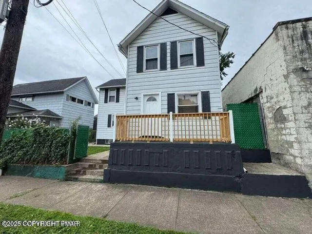 a view of house with a yard next to a road