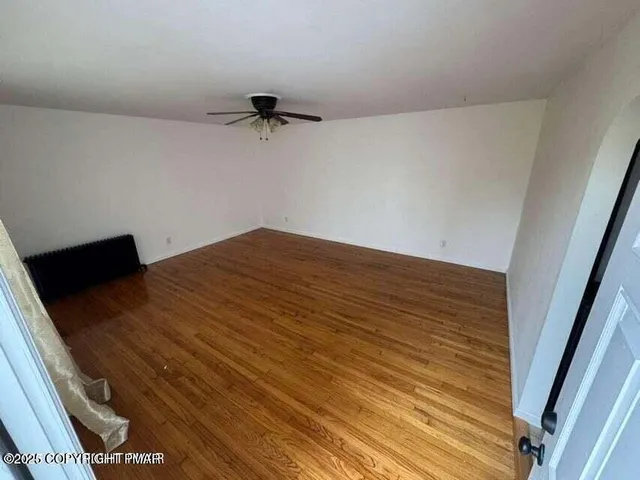 a view of a room with wooden floor