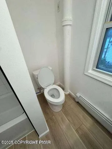 a bathroom with a toilet a sink and a window