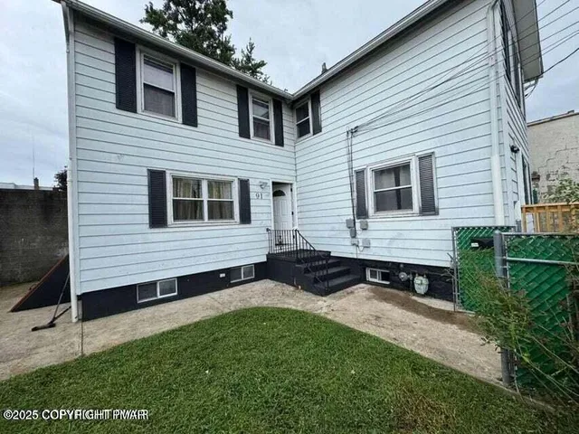 a view of a house with backyard and sitting area