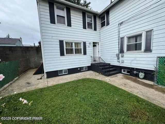 a view of a house with backyard and sitting area