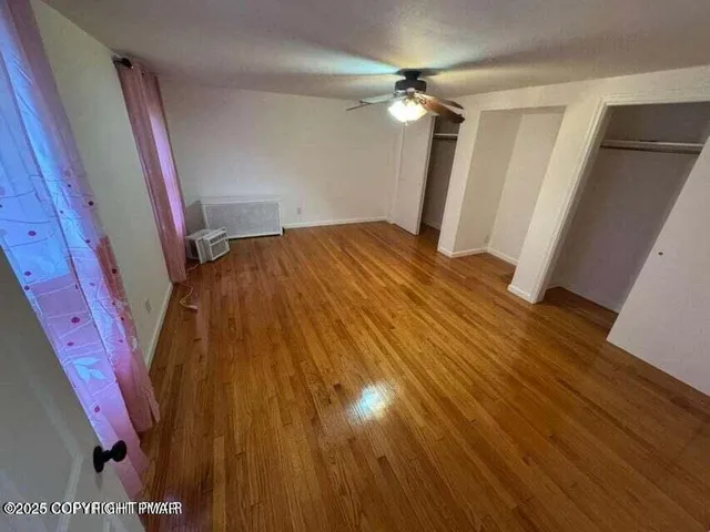 a view of empty room with wooden floor